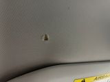 a hole in the ceiling of a car that has a warning sticker on it