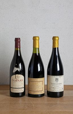 three bottles of wine are lined up on a wooden table
