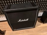 a black amp sitting on the floor in front of a speaker