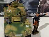 two toy soldiers standing next to a toy tank