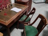 des tables et des chaises dans une pièce où un tapis est accroché au mur