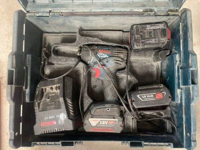 une boîte à outils contenant des outils, posée sur le sol