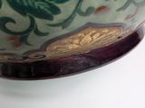 a green and red bowl sitting on top of a white table