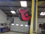 un objet rouge et noir suspendu à un poteau dans un garage