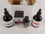 three bottles of ink sitting next to each other on a table