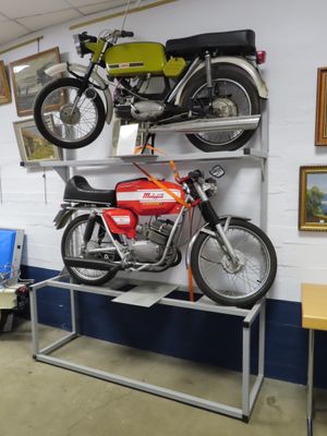 two motorcycles that are sitting on a shelf in a room