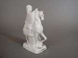 a figurine of a man riding on a horse