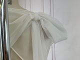 a white chair with a bow tied to it ' s back