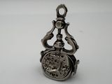 a small silver pocket watch on a white surface