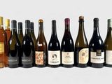 bottles of wine are lined up in a row on a white surface