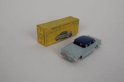 a small toy car next to a box on a white surface