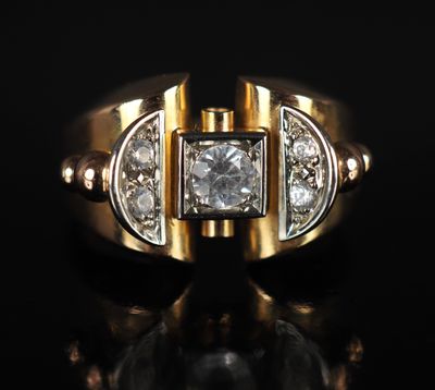 gros plan d'une bague en or avec des diamants sur une surface noire