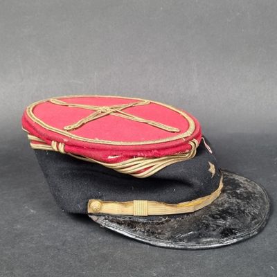 un chapeau rouge orné d'une croix sur fond noir
