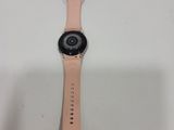 a close up of a watch on a white surface with a pink strap
