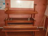 a wooden bench with a mirror on it in a room