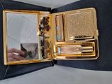 a gold case with a mirror and a brush in it