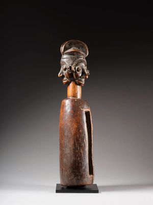 une sculpture en bois représentant une femme coiffée d'une coiffe