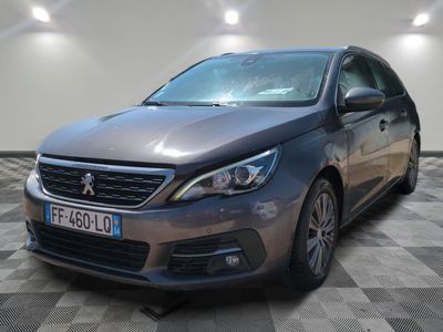 une voiture grise est garée dans une pièce au sol à carreaux