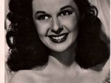 an old black and white photo of a woman with a smile on her face