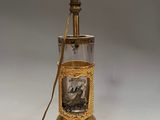 une lampe à l'ancienne avec, à l'intérieur d'une bouteille en verre, l'image d'un homme et d'une femme