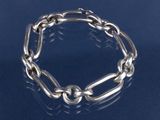bracelet en argent composé de maillons et de perles sur un fond bleu
