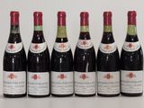 six bottles of wine are lined up in a row on a table
