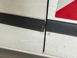 a red and white sign on the side of a white van