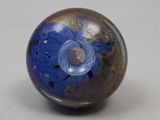 a glass ball with a hole in it on a white surface