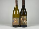 deux bouteilles de vin posées l'une à côté de l'autre sur une surface blanche