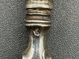 a silver spoon with a design on it sitting on a table