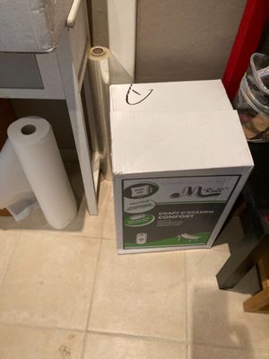 une boîte de papier toilette et un rouleau de papier toilette par terre