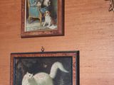 a cat that is standing in front of a painting on the wall