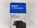 une photo d'une boîte de plaquettes de frein « Delphi Technologies » posée sur une surface blanche