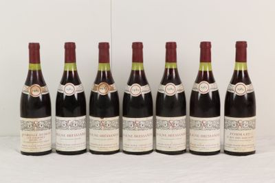 six bouteilles de vin sont alignées sur une table