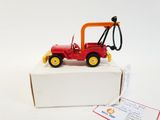 a red toy tractor with a yellow handle on a white box