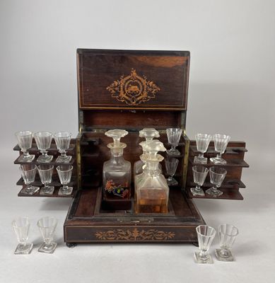 une boîte en bois contenant un service de verres et une bouteille d'alcool