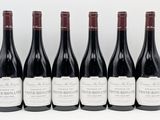 six bottles of red wine lined up in a row