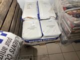 a pile of mattresses sitting on the floor next to a pile of bags