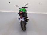 a green motorcycle parked in a room with a white wall