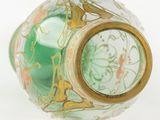 a green glass vase with a gold decoration on it
