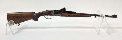 Le fusil est exposé sur un socle en acrylique transparent.