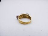 a close up of a gold ring with two pearls on it