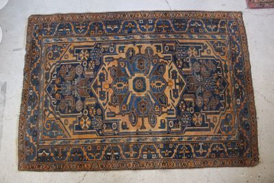 Le tapis posé au sol est bleu et marron, avec un motif.