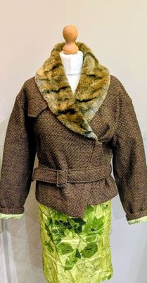un mannequin portant une jupe verte et une veste marron