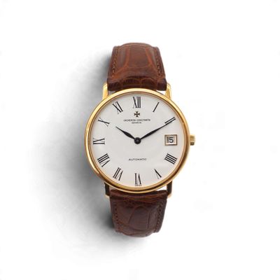 un gros plan d'une montre-bracelet avec des chiffres romains sur fond blanc