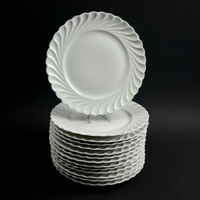 des assiettes blanches empilées les unes sur les autres sur un fond noir