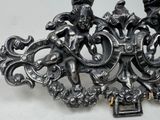a silver brooch that has a picture of a man and a woman on it