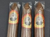 four cigars are lined up in a row on a black surface