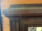 a wooden cabinet with a mirror on top of it