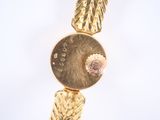 a close up of a gold bracelet with a clock on it